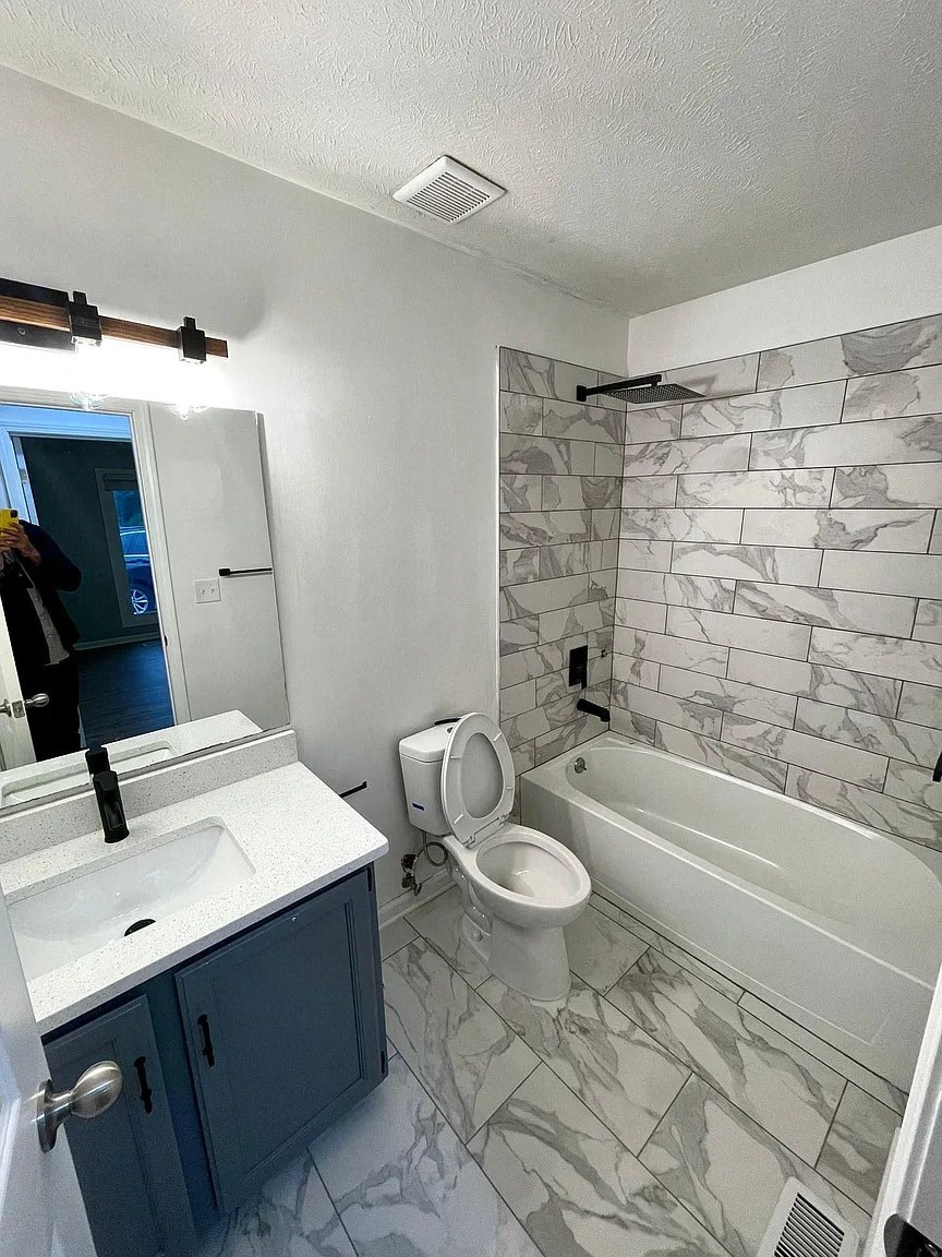 a bathroom with a toilet and a sink and a bath tub