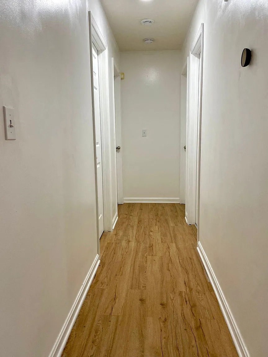 a hallway with wood floors and white walls
