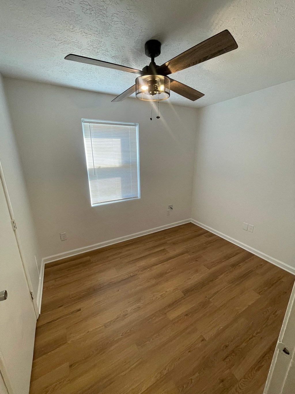 a bedroom with hardwood floors and a ceiling fan