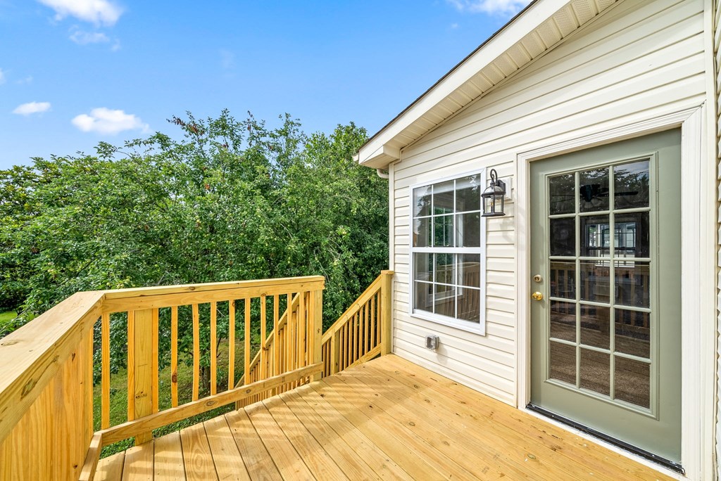 a backyard deck with a door and a house