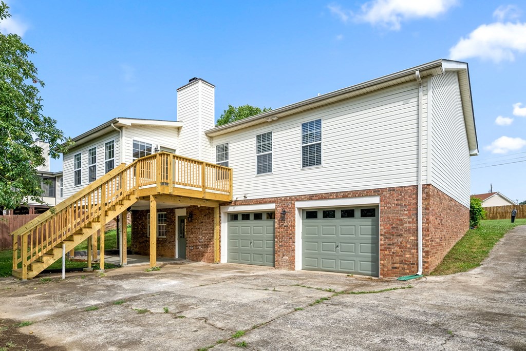 the back of a house with two garages and a deck