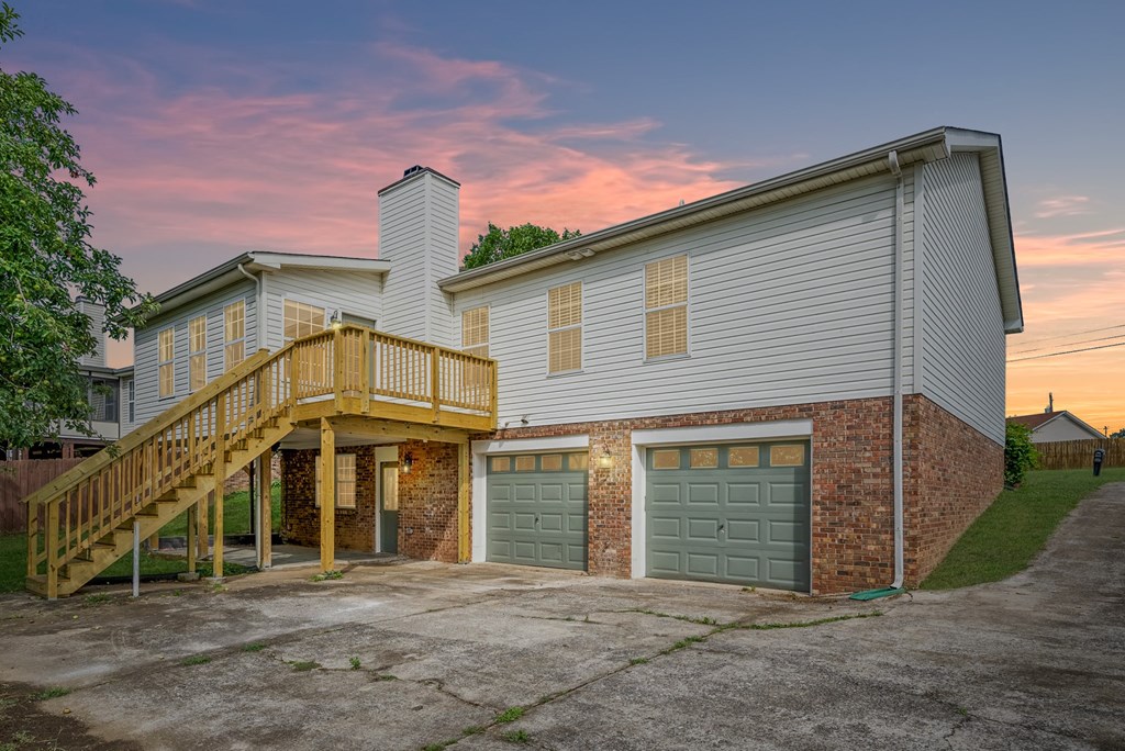 the back of a house with two garage doors and a deck