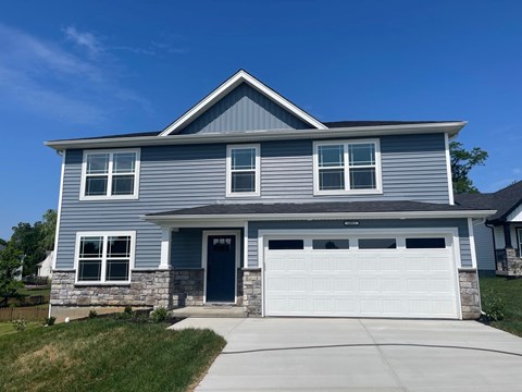 A house with a grey siding and a white garage door.
