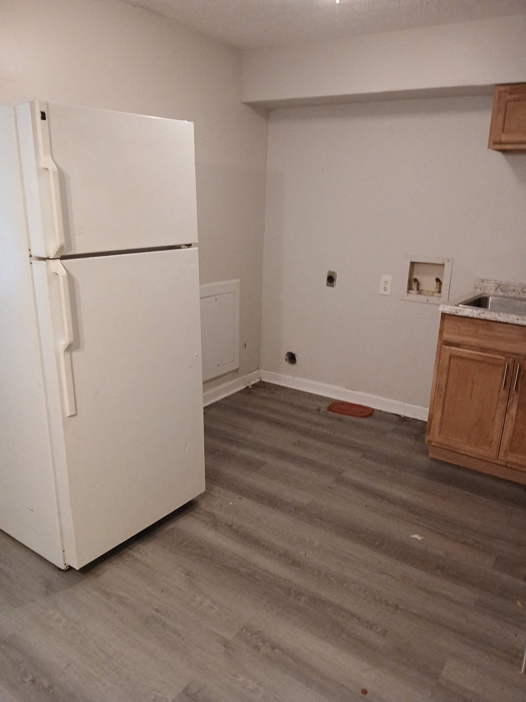 a kitchen with a refrigerator and wooden floors