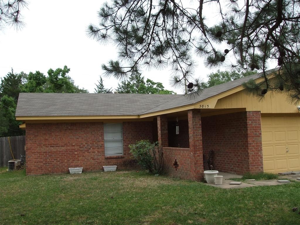 A house with a yellow garage door and a brick exterior.
