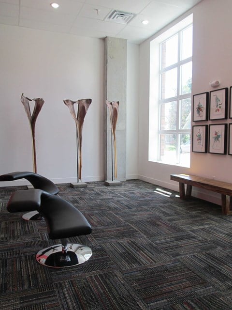 a living room with a chair and sculptures on the wall