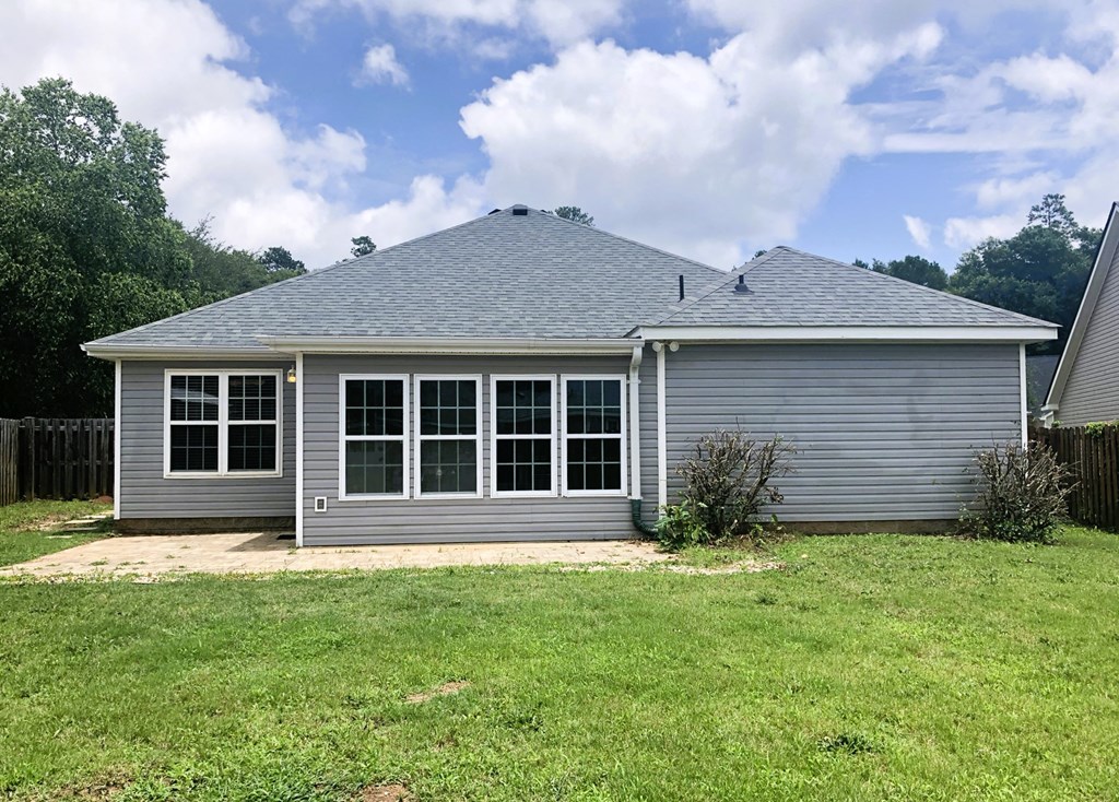 a home with a grey roof and a grassy yard