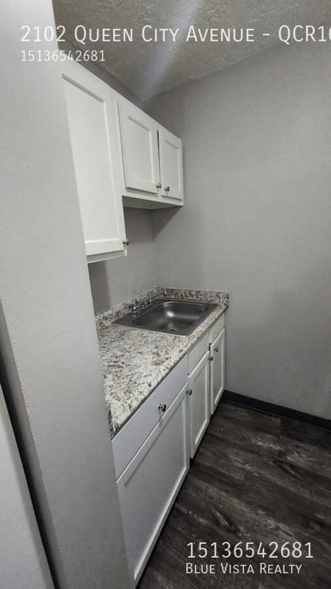 A kitchen with white cabinets and a granite countertop.