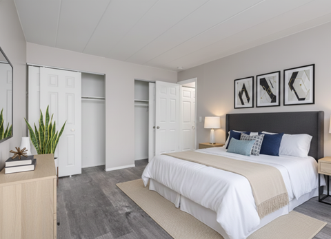 A bedroom with a large bed and a wooden dresser.