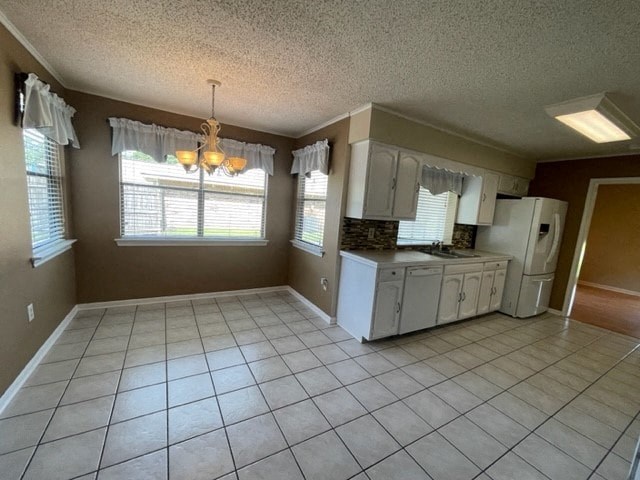 an empty kitchen with white appliances and tile floor