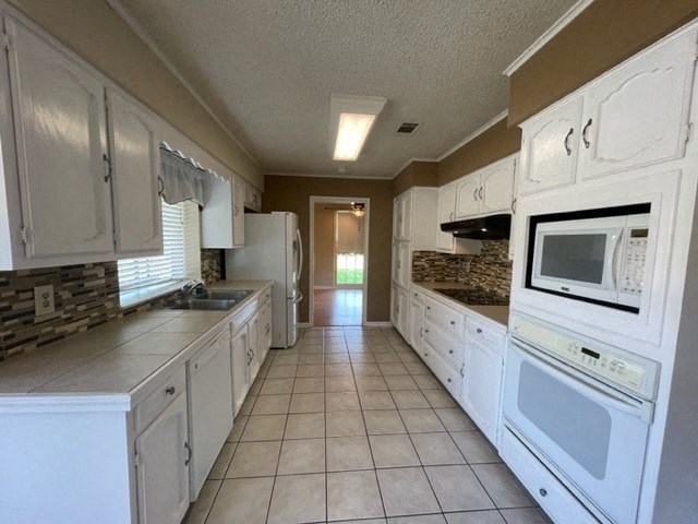 a large kitchen with white cabinets and a microwave