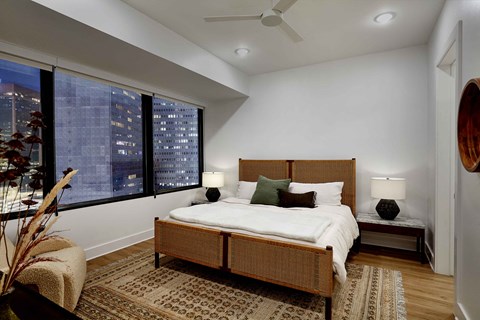 a bedroom with a bed and a large window