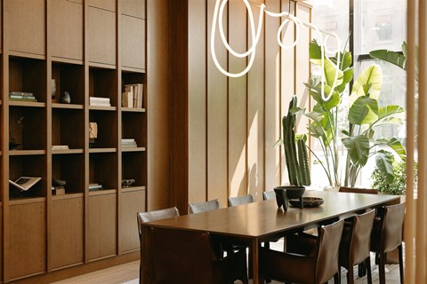 a dining room with a wooden table and chairs and a large window