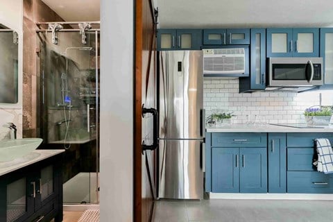 a kitchen with blue cabinets and a stainless steel refrigerator
