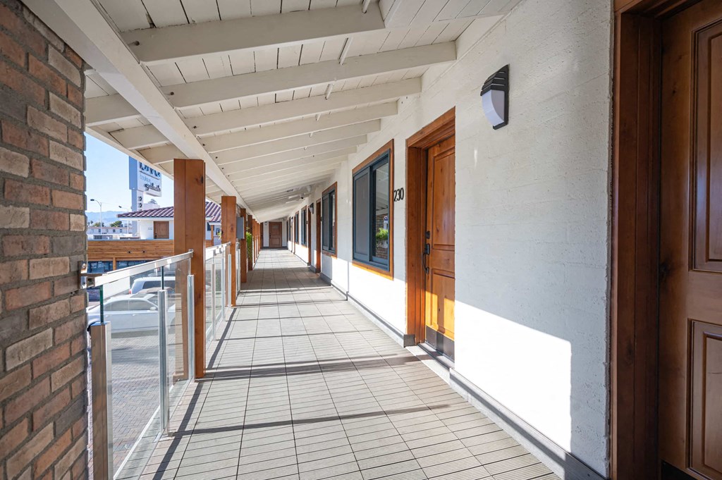 a corridor with wooden doors and a tiled floor