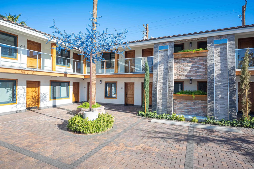 a courtyard with a tree in front of a building