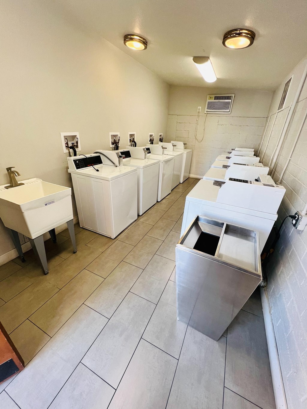a room with several sinks and a row of sinks in it