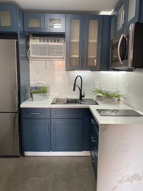 a kitchen with blue cabinets and a sink and a refrigerator
