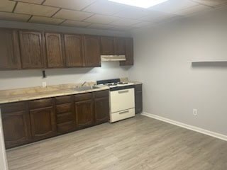 A kitchen with a white dishwasher and wooden cabinets.