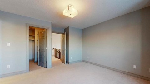 an empty living room with a blue wall and a staircase