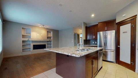 a kitchen with a marble counter top and a refrigerator