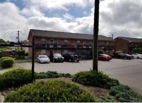 A parking lot with cars and a building in the background.