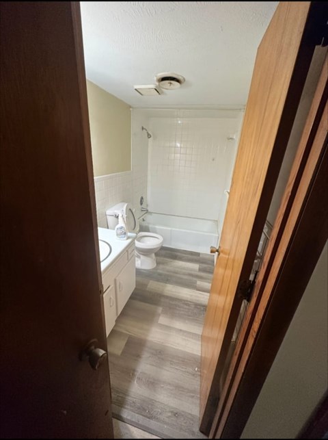 A bathroom with a toilet, sink, and shower.