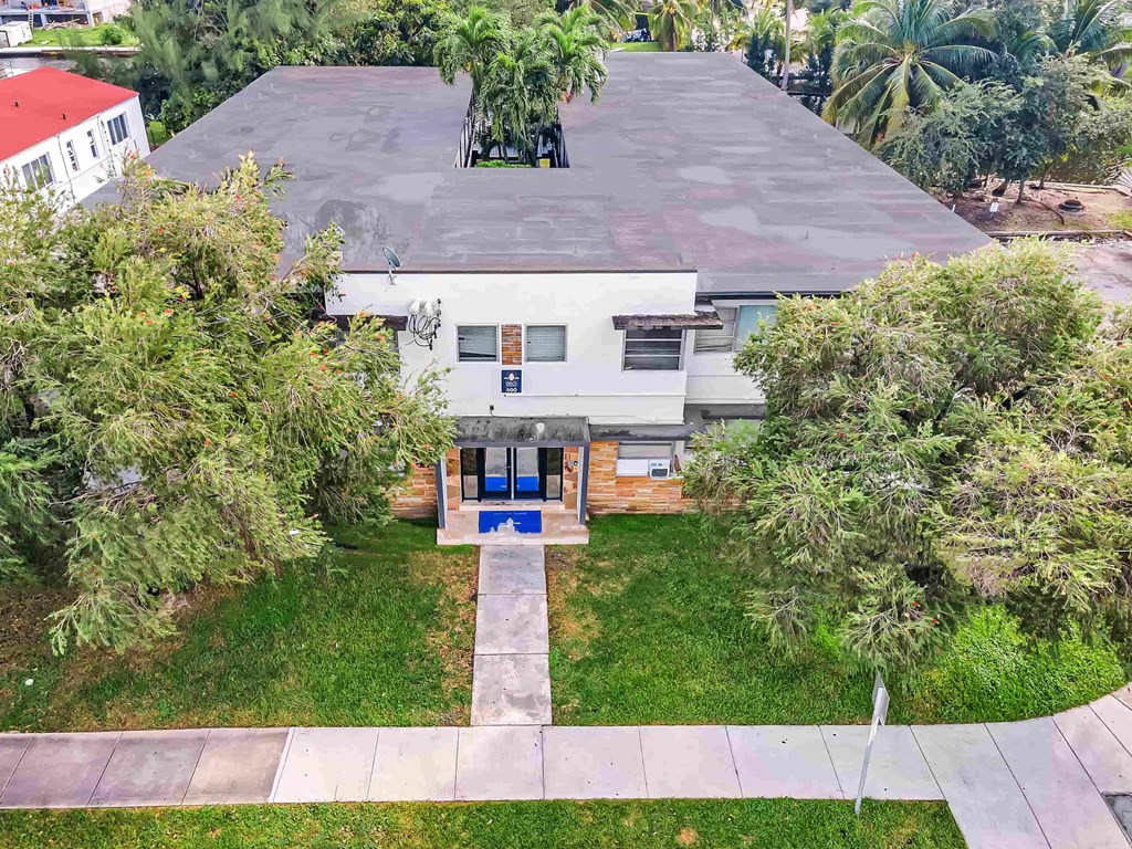 A house with a blue door surrounded by greenery.
