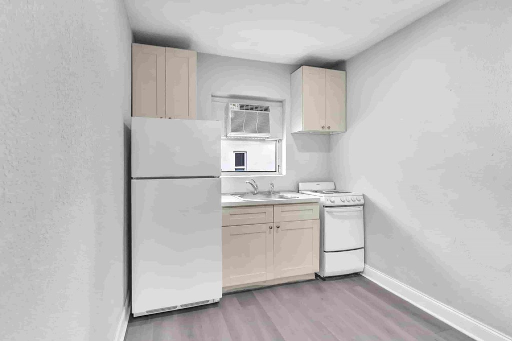 a kitchen with a sink and a refrigerator and a stove