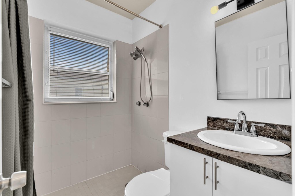 A bathroom with a white sink and a shower.