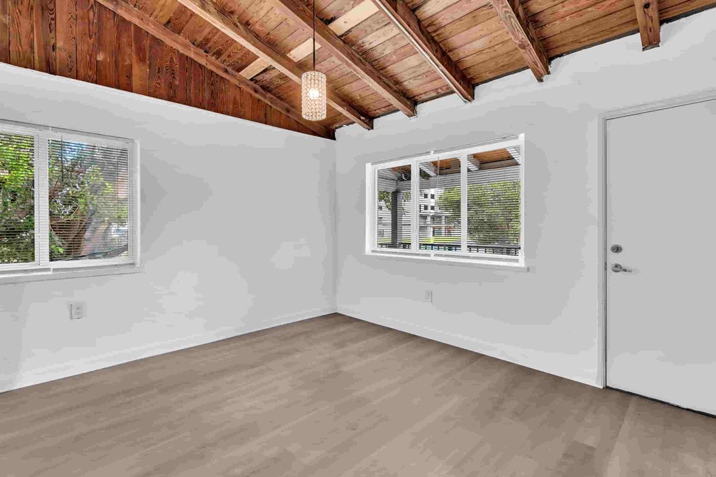 A room with a wooden ceiling and a window with blinds.