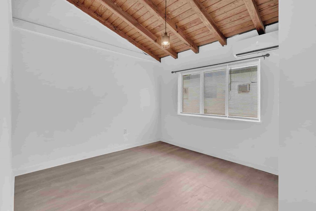 A room with a window and a wooden ceiling.