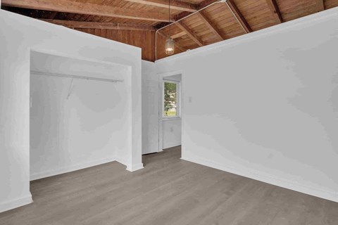 an empty room with white walls and a door to a closet