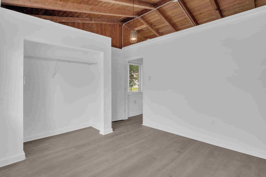 A room with white walls and wooden ceiling.