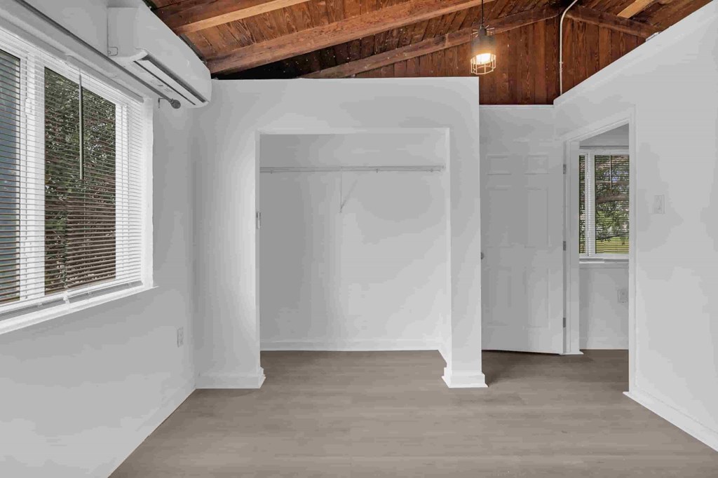 A room with white walls and wooden ceiling is shown.