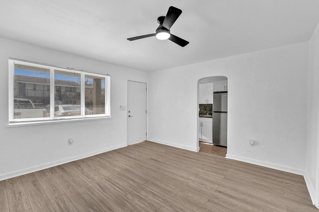 A room with a ceiling fan and a window with blinds.
