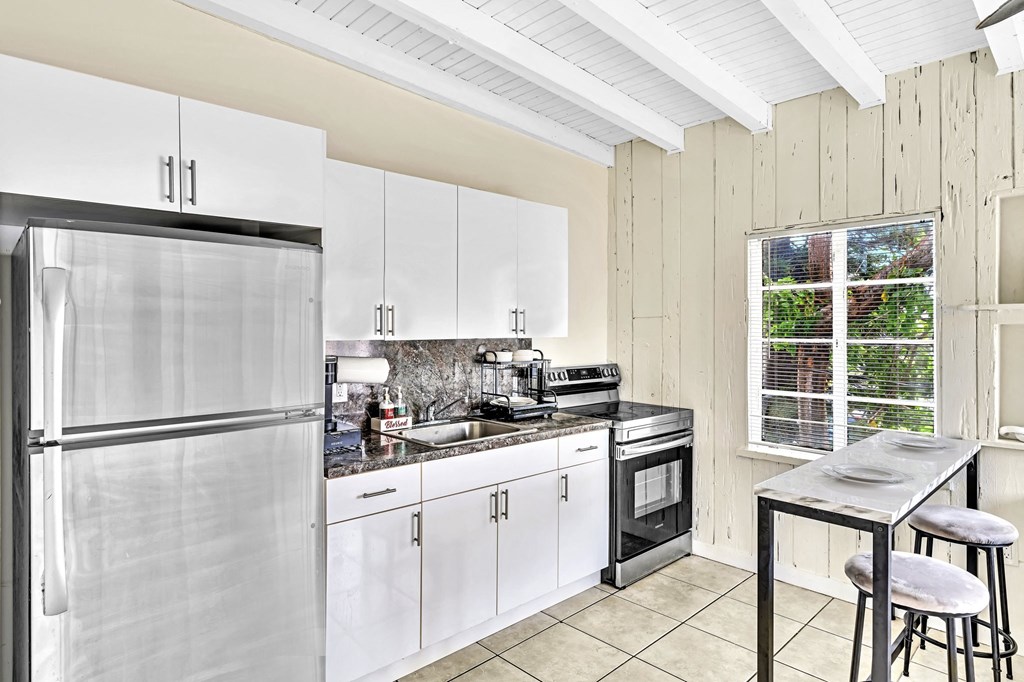the kitchen has stainless steel appliances and white cabinets
