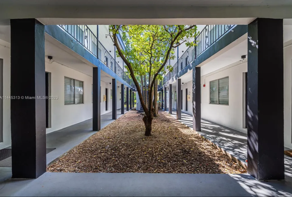 a corridor with a tree in the middle of a building