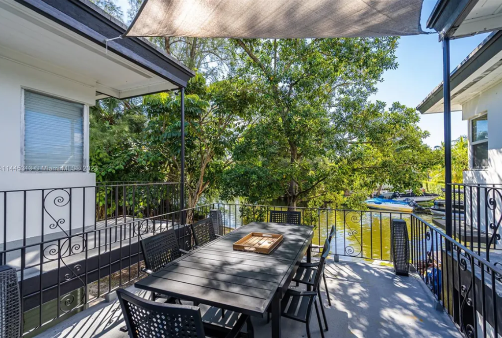 a dining area with a table and chairs on a balcony