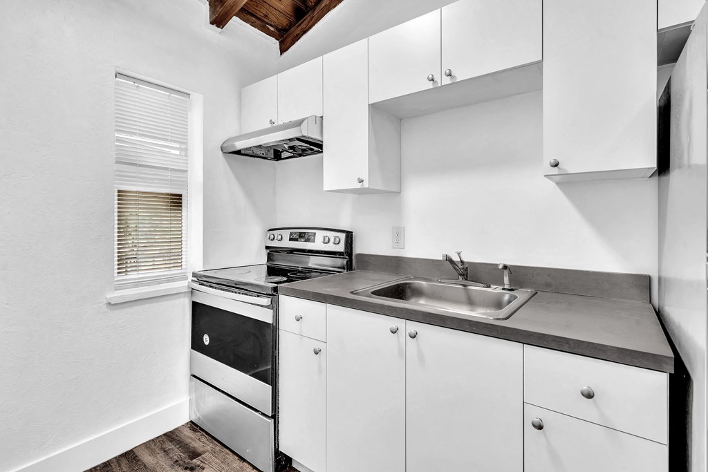 a kitchen with white cabinets and black appliances and a sink