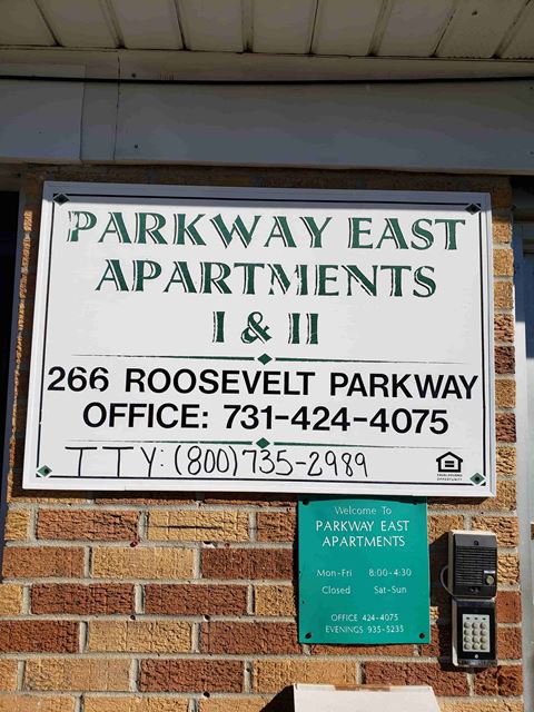 a sign for parkway east apartments on a brick building