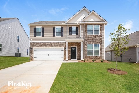 a house with a white garage door in front of a green lawn