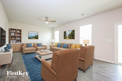 A living room with a blue rug and brown couches.