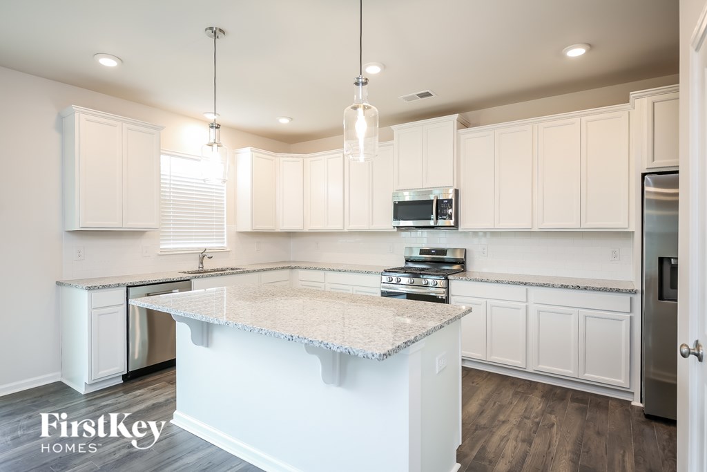 A kitchen with a white countertop and cabinets.
