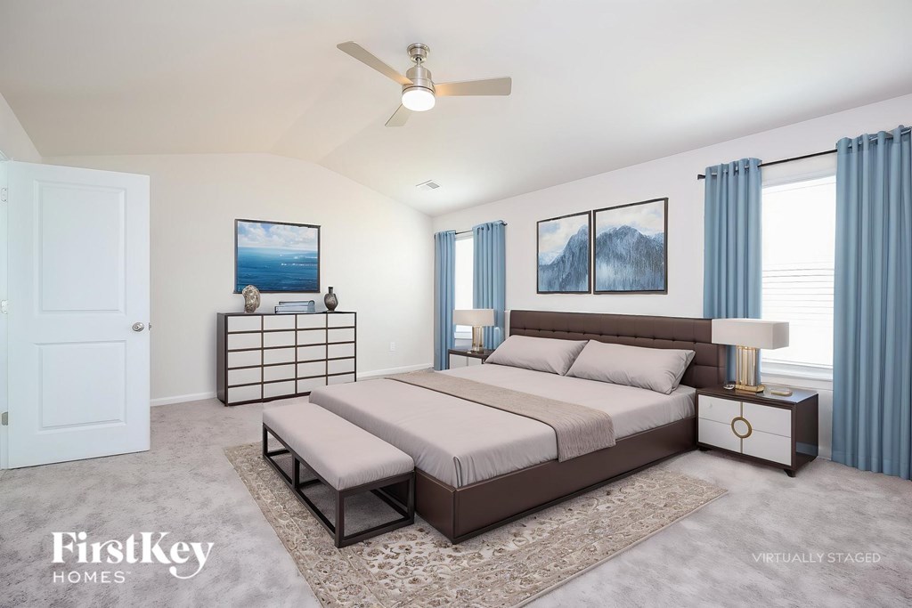 A bedroom with a bed, nightstand, and a ceiling fan.