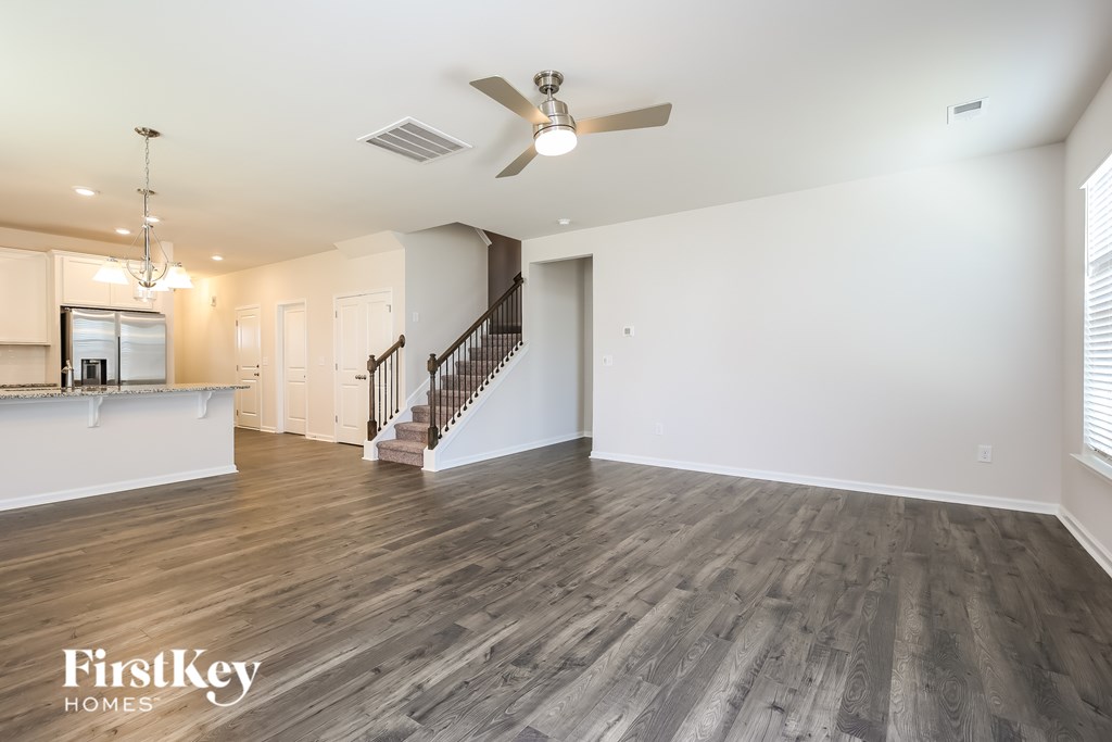 A spacious living room with a staircase leading to the upper floor.