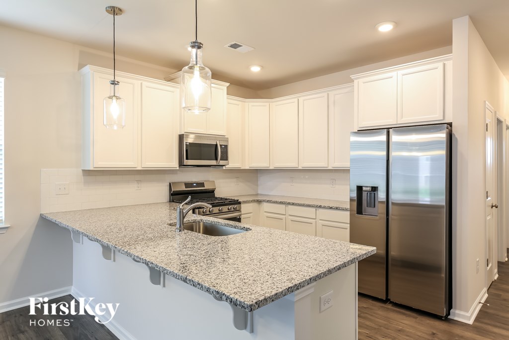 A kitchen with a granite countertop and stainless steel appliances.