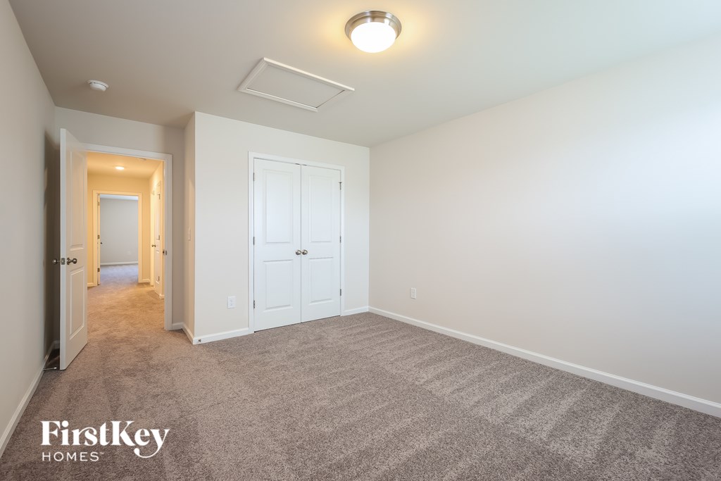 A carpeted room with a FirstKey Homes logo.