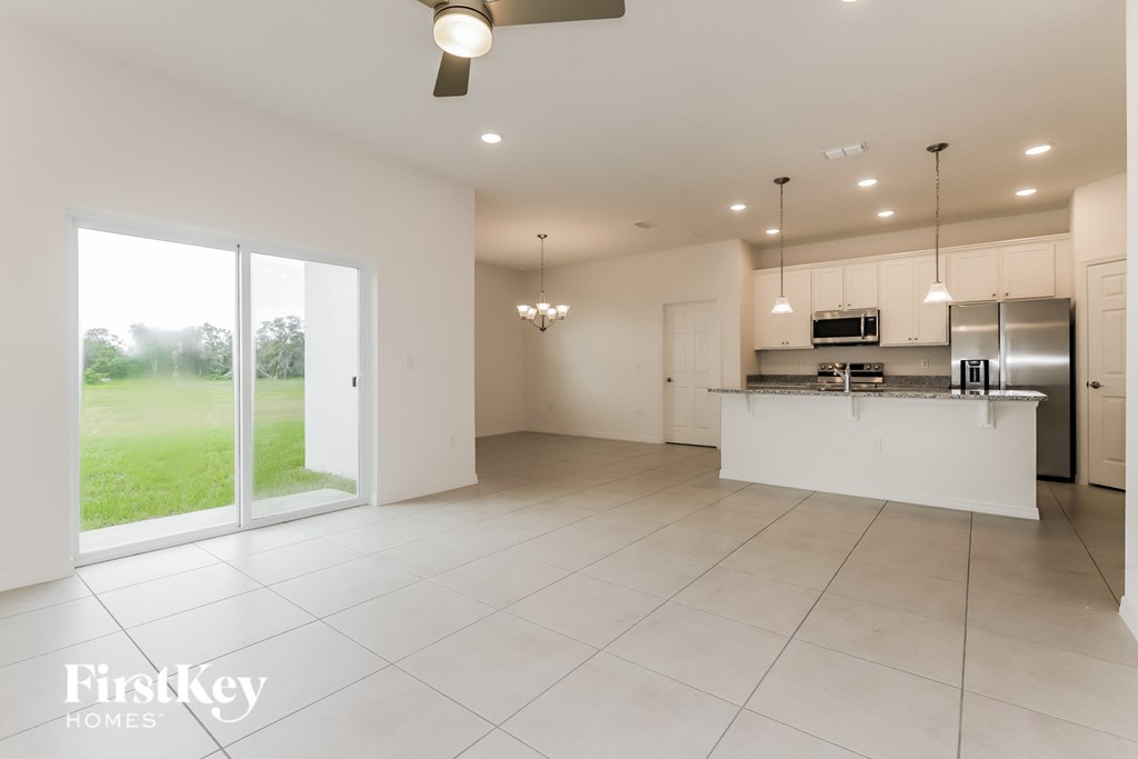an open kitchen and living room with sliding glass doors to the backyard