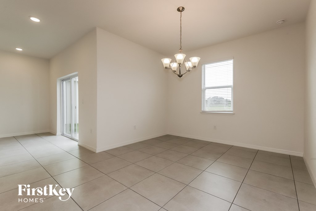 an empty dining room with tiled flooring and a window